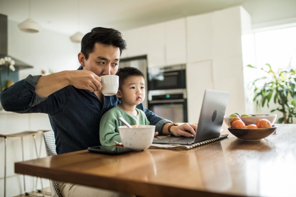 A man working from home with a young child.