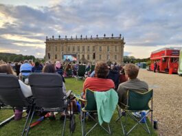 Audience sitting on picnic blankets at an outdoor cinema event at Chatsworth House.